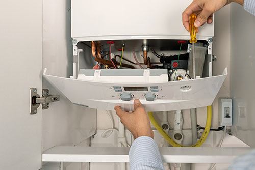 HVAC technician repairing an indoor boiler in Tempe