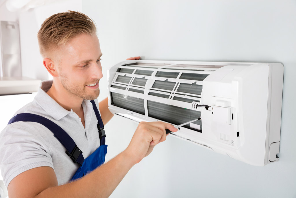 HVAC technician performing ductless air conditioning maintenance in Tempe