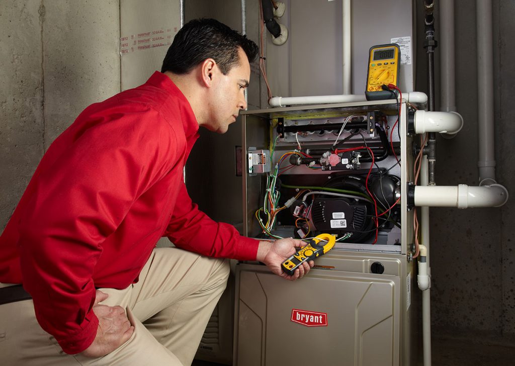 HVAC technician repairing an indoor furnace in Tempe