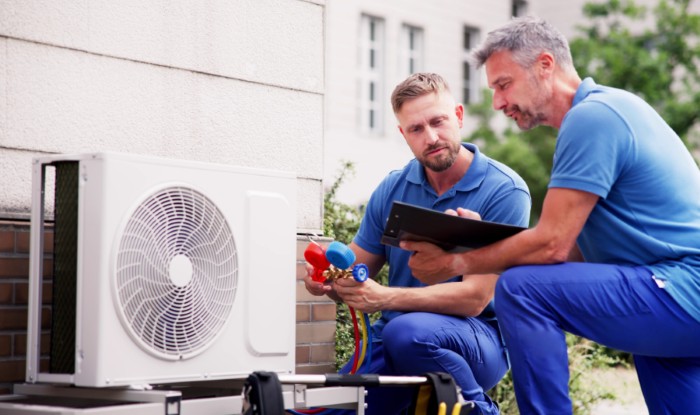 HVAC technicians installing an outdoor air conditioning unit in Tempe