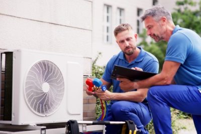 ac-installation-in-claremont-ca HVAC technicians reviewing an outdoor air conditioning unit in Tempe, AZ