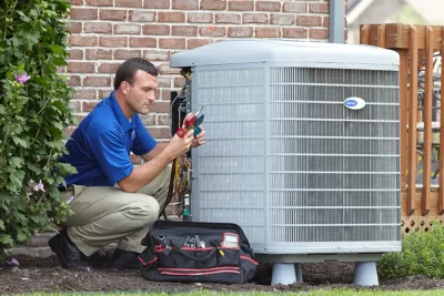 design-air-heating-and-air-conditioning-decatur-il-05 – Copy HVAC technician inspecting an outdoor air conditioning unit in Tempe, AZ