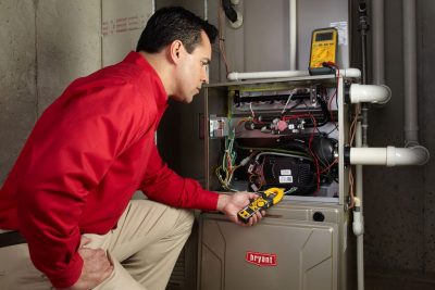 furnace repair Heating and air conditioning technician servicing an indoor furnace in Tempe, AZ